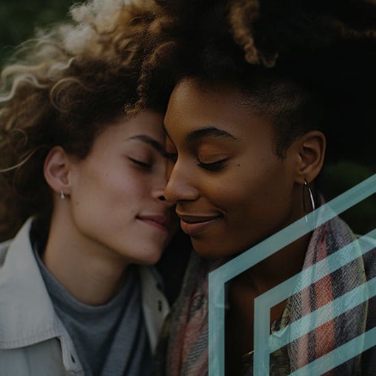 Two women with closed eyes sharing a tender moment outdoors. One woman has light curly hair, and the other has dark curly hair. Both appear content and close to each other, with one resting her head on the other's shoulder.